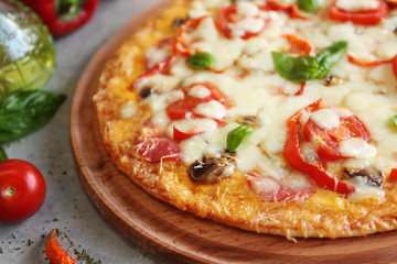 Tasty pizza with ingredients on table