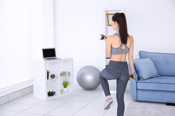 Attractive fitness woman exercising at home