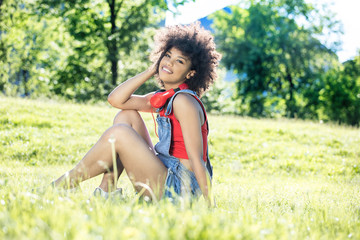 Naklejka na ściany i meble African american girl relaxing outdoor with headphones.