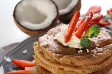 Stack of delicious coconut pancakes with strawberry and butter cream, close up
