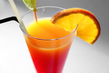 Delicious Tequila Sunrise cocktail in glass, closeup