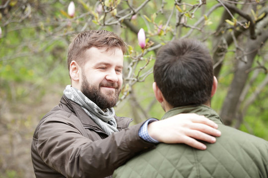 Happy gay couple hugging in spring park