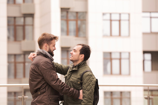 Happy gay couple hugging outdoors