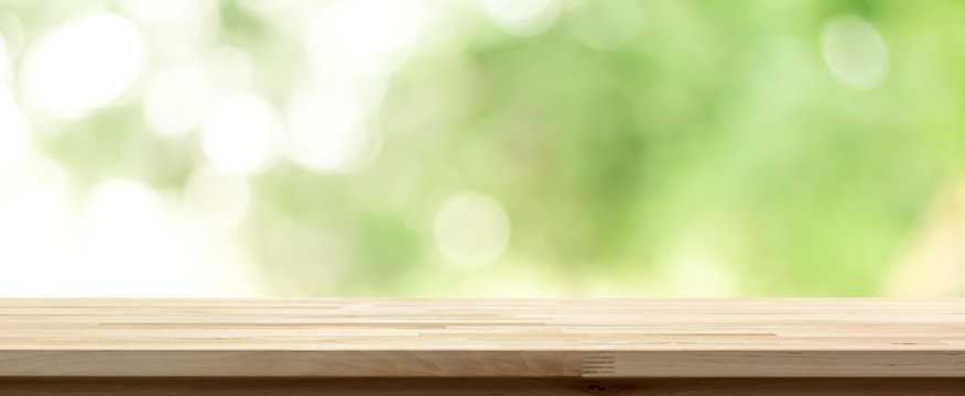 Wood table top on  blur abstract natural green background, panoramic banner