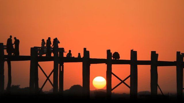 Sunset at U Bein Bridge,Mandalay, Myanmar. The bridge was built around 1850 is a crossing that spans the Taungthaman Lake and  believed to be the oldest and longest teakwood bridge in the world.