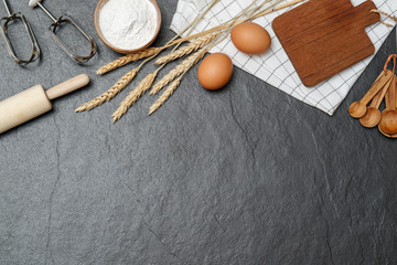 Top view kitchen utensils and baking ingredients mockup on dark border background  with notebook and pencil.
