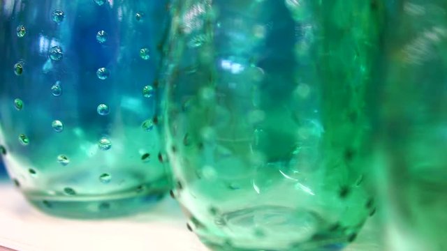 Colorful glass bottles and vases. Close up abstract vivid rainbow color material