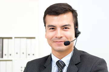 Smiling handsome businessman wearing microphone headset as an operator