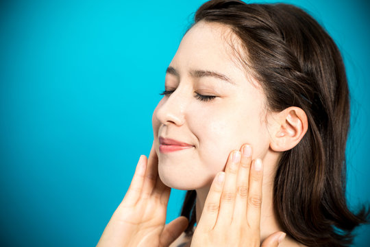 young beauty woman massaging her face, facial lymphatic massage