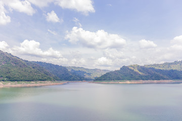 Landscape of natural dam mountain and water reservoir under cloudy sky, natural irrigation system.