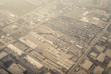 Aerial view of an industrial area seen through a light layer of clouds