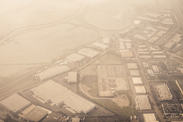 Aerial view of an industrial area seen through a light layer of clouds