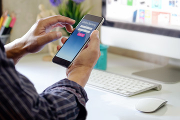 Man with online bank application phone at desk workspace in office. e-banking concept.
