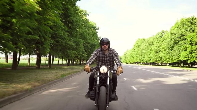 Biker riding a motorcycle on a road surrounded by trees