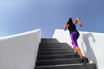 Stairs running workout woman training cardio at gym. Fitness girl exercising legs muscles outdoors...