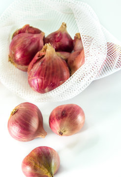 Red Onions In Mesh Bag  Isolated On White Background