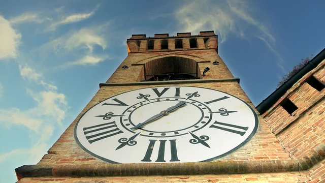 timelapse of clouds moving behind ancient clock tower in Italy