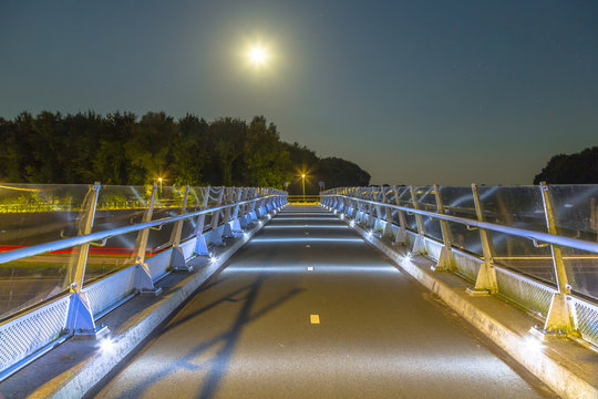 Fototapeta Cycling bridge with low level illumination