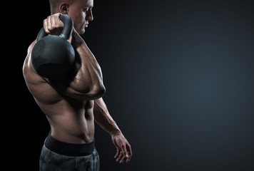 Cropped shot of young bodybulder holding a kettle bell Strong fitness male exercising crossfit with...