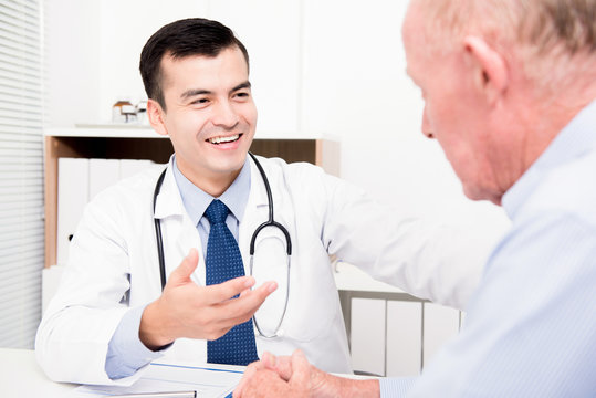 Smiling doctor consulting with senior male patient