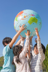 地球儀を持ち上げる小学生