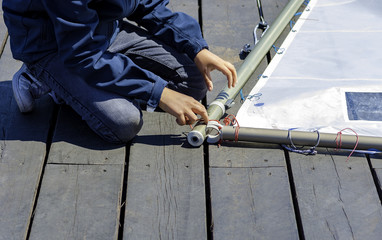 aspiring sailor prepares the sail of his boat the sailing course.