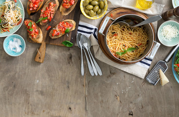 Italian dinner table with pasta and bruschetta on wooden table