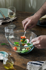 Man preparing dinner from salad in home kitchen
