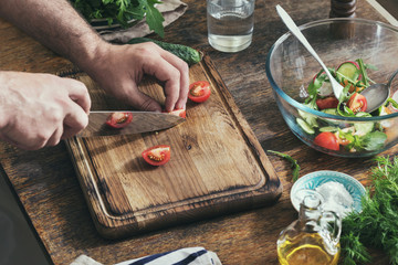 Man preparing breakfast from salad in home kitchen