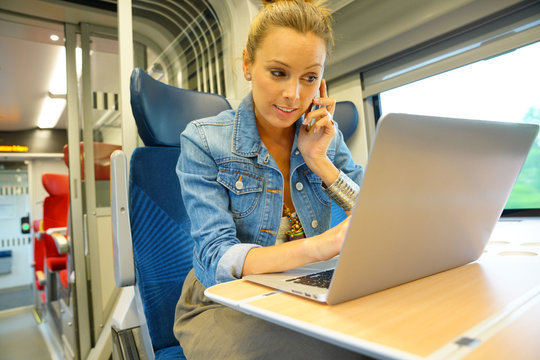 Young woman in train connected on laptop computer
