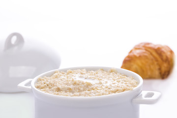 Oat porridge in a white saucepan. Oatmeal. Cap..