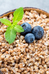 Buckwheat porridge in a bowl with mint leaves and blueberries.