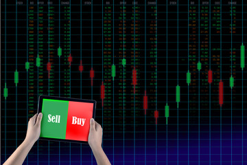 Holding tablet to show screen sell or buy isolated with background stock market graph run number...