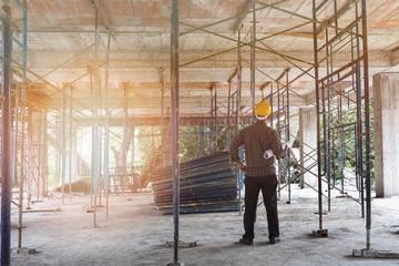 Engineer with blueprint in building construction site