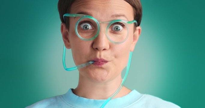 wondering woman drinks using drinking straw glasses with blue liquid