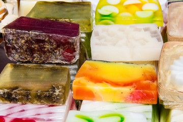 Stack of different natural handmade soaps on retail market