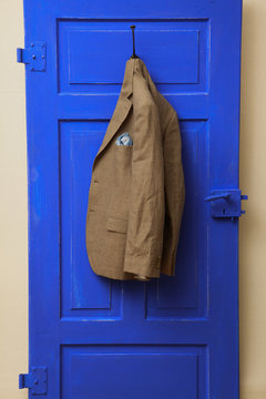 fashionable men sakko hangs on blue door