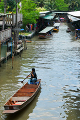 Obraz premium Man in Boat at traditional Floating Market in Thailand
