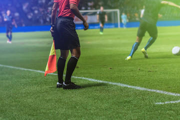 Lineman assistant referee with flag Officiate soccer game beside soccer field.