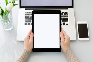 Female hands holding computer tablet with isolated screen near laptop