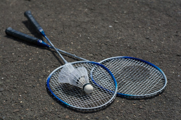 Badminton rackets and shuttlecocks on grey background - summer, street game 