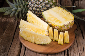 Ripe pineapple and pineapple slices on a wooden background tropical fruits