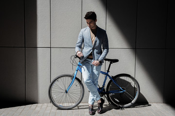 Thoughtful male person standing near bike