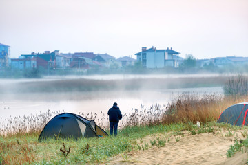 Green tent and a man near river