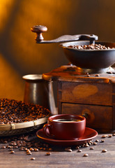 Cup of black coffee , coffee grinder and roasted beans