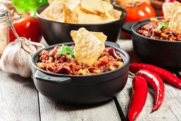 Bowls of hot chili con carne with ground beef, beans, tomatoes and corn