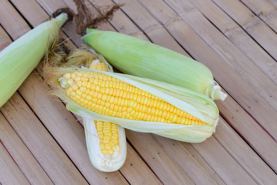 Fresh corn on cobs on rustic wooden