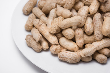 Dried peanuts on white plate at on white background