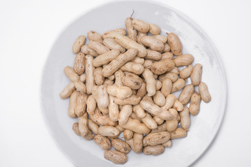 Dried peanuts on white plate at on white background