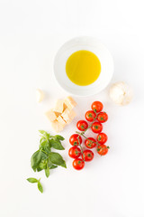 Italian food with red tomatoes, pasta, basil leafs, cheese, garlic, isolated on white background